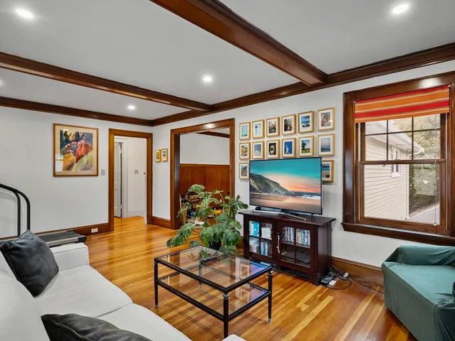 a living room with furniture a flat screen tv and a floor to ceiling window