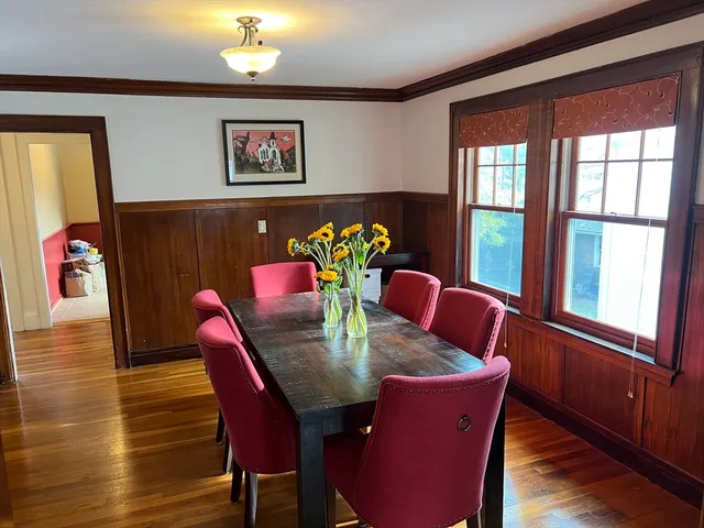 a view of a dining room with furniture a chandelier and wooden floor