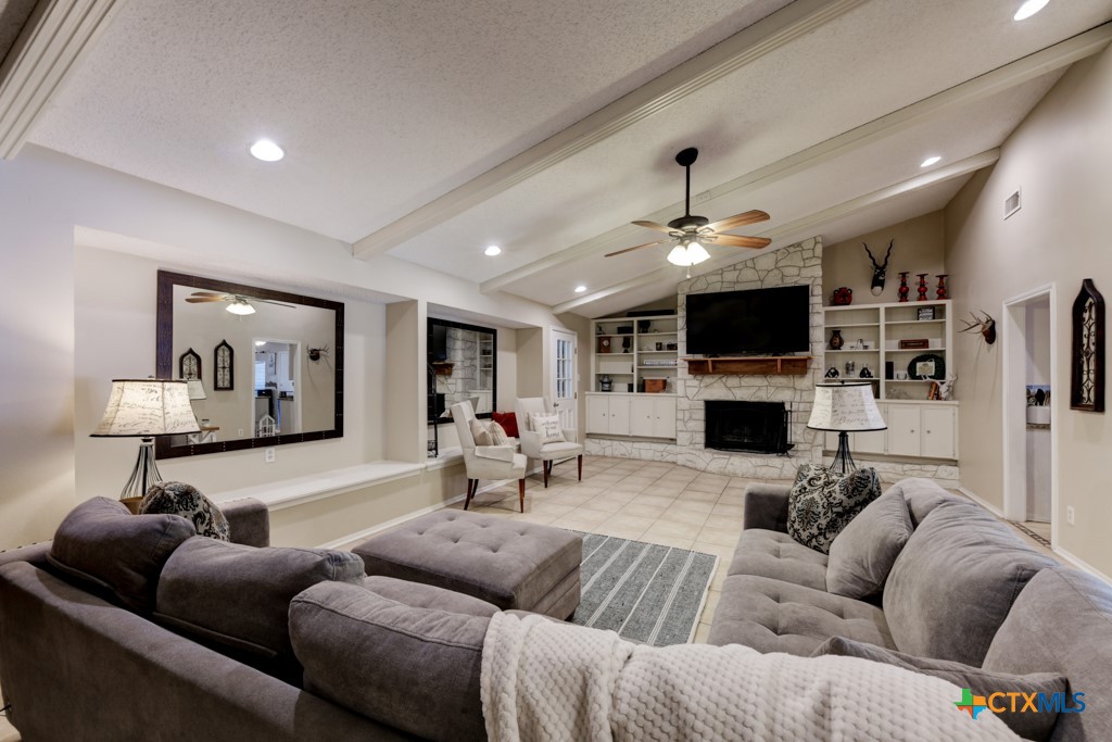 1229 Rapids Road New Braunfels, TX 78130 - Photo 5 of 27 a living room with furniture a fireplace and a flat screen tv