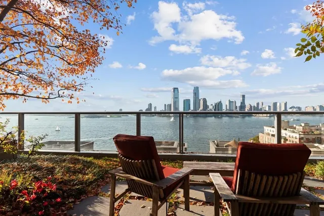 a view of a balcony with chairs and a potted plant