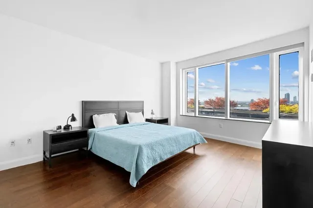 a bedroom with a bed and a large window