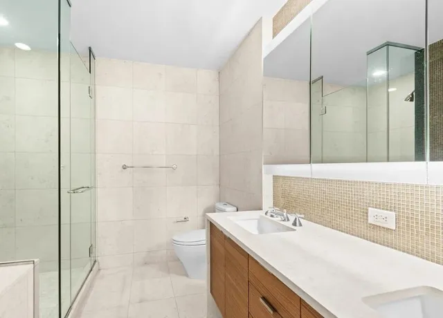 a bathroom with a sink a toilet and shower