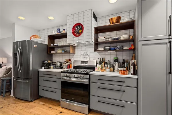 a kitchen with stainless steel appliances granite countertop a lot of counter space and wooden floor