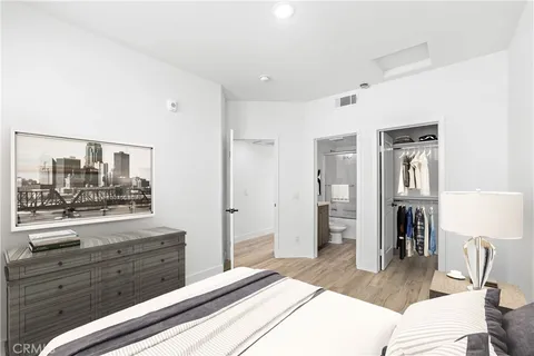 a bedroom with a bed and a mirror on the dresser
