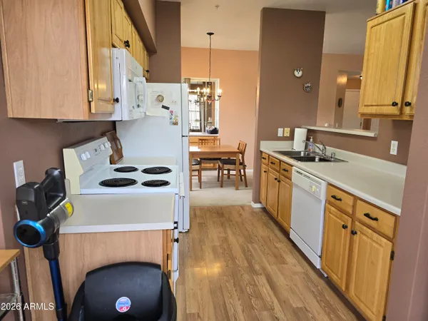 a kitchen with a refrigerator a sink and wooden floor
