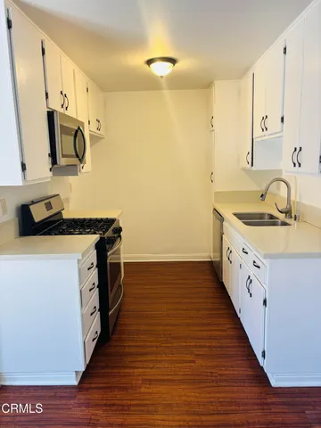 a kitchen with sink a stove and cabinets