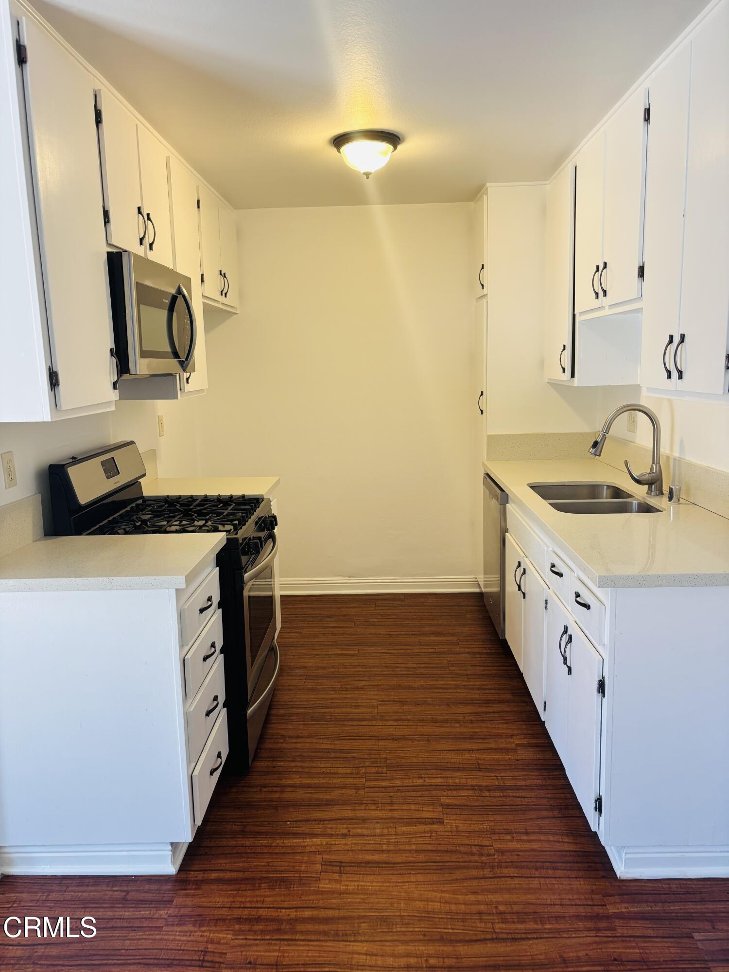 a kitchen with sink a stove and cabinets