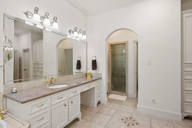 a spacious bathroom with a granite countertop sink a mirror and a shower