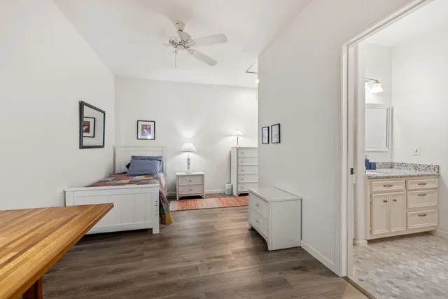 a kitchen with stainless steel appliances granite countertop white cabinets a sink a stove a microwave and wooden floors