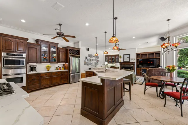 a kitchen filled with stainless steel appliances kitchen island granite countertop a sink and cabinets