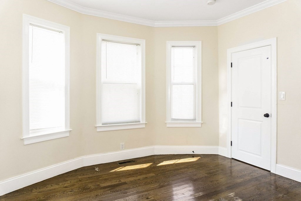 71 Walnut Park Boston, MA 02119 - Photo 11 of 36 an empty room with wooden floor and windows