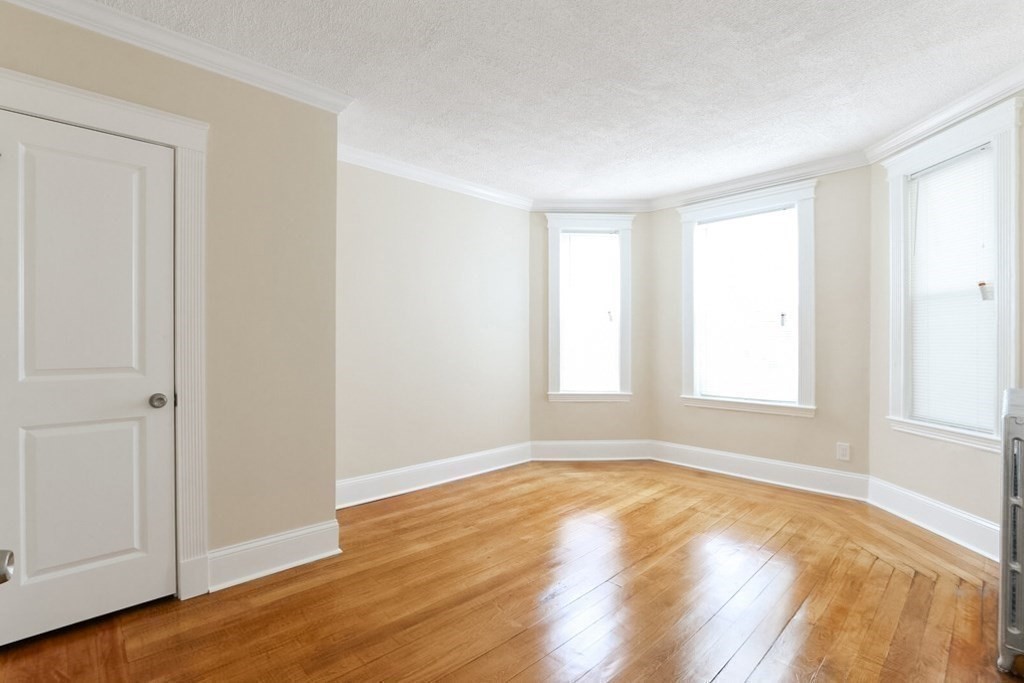71 Walnut Park Boston, MA 02119 - Photo 12 of 36 a view of empty room with wooden floor and fan