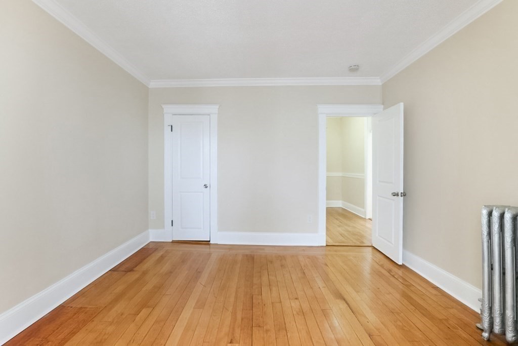 71 Walnut Park Boston, MA 02119 - Photo 15 of 36 an empty room with wooden floor