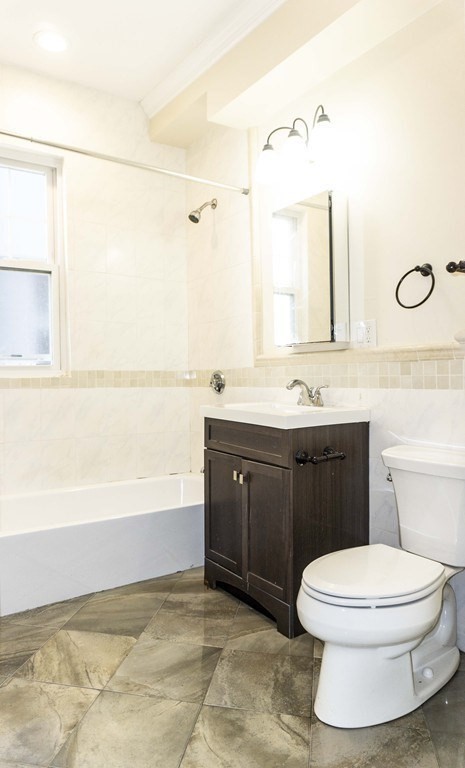 71 Walnut Park Boston, MA 02119 - Photo 16 of 36 a bathroom with a sink a toilet and mirror