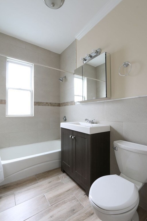 71 Walnut Park Boston, MA 02119 - Photo 29 of 36 a bathroom with a sink a toilet a vanity and mirror