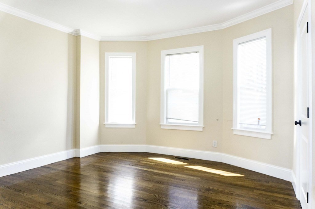 71 Walnut Park Boston, MA 02119 - Photo 31 of 36 a view of an empty room with wooden floor and a window