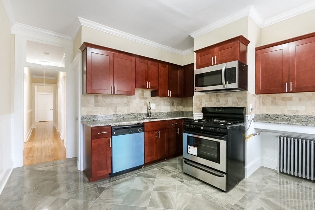 71 Walnut Park Boston, MA 02119 - Photo 8 of 36 a kitchen with stainless steel appliances granite countertop a stove microwave and sink