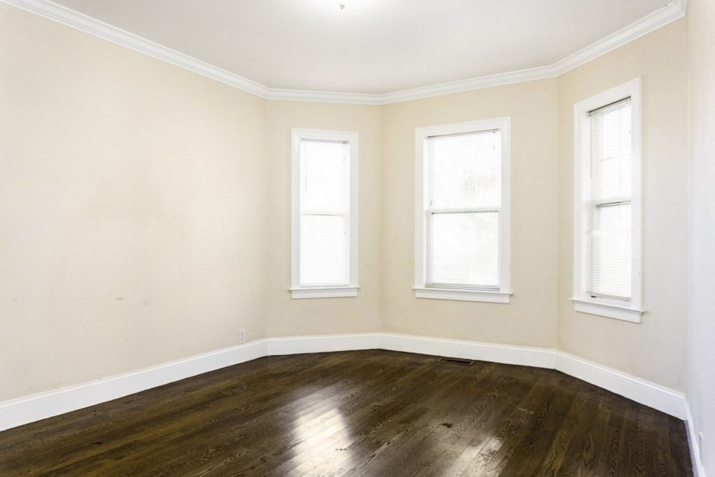 71 Walnut Park Boston, MA 02119 - Photo 10 of 36 an empty room with wooden floor and windows