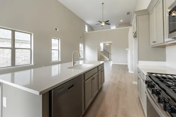 a kitchen with granite countertop a sink appliances cabinets and a counter top space