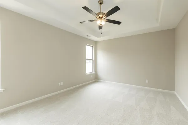 an empty room with a window and a fan