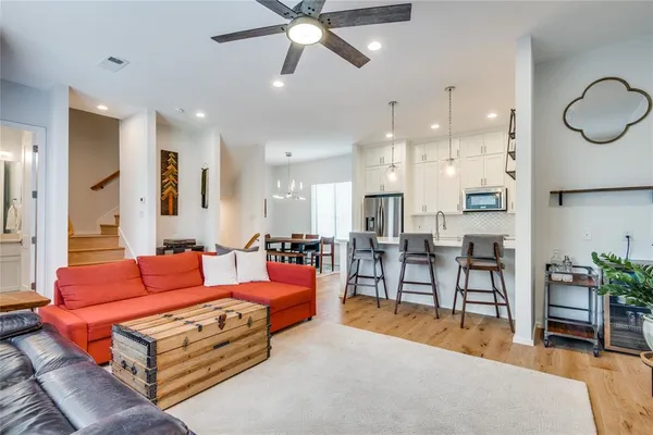 a living room with furniture kitchen view and a chandelier