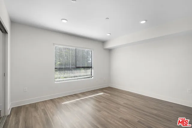 an empty room with wooden floor and a window
