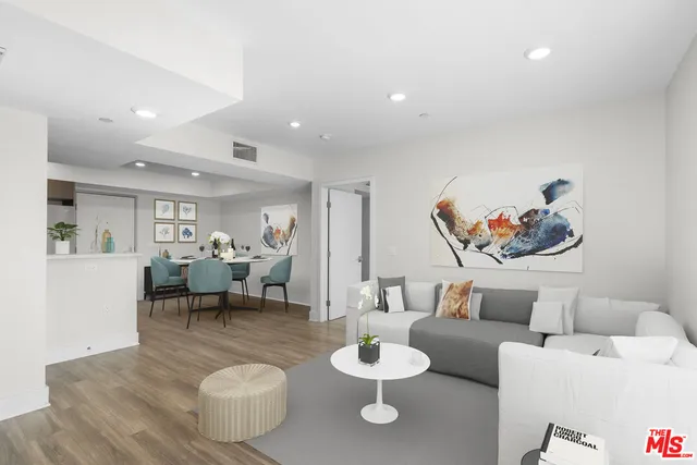 a living room with furniture and a dining table with wooden floor