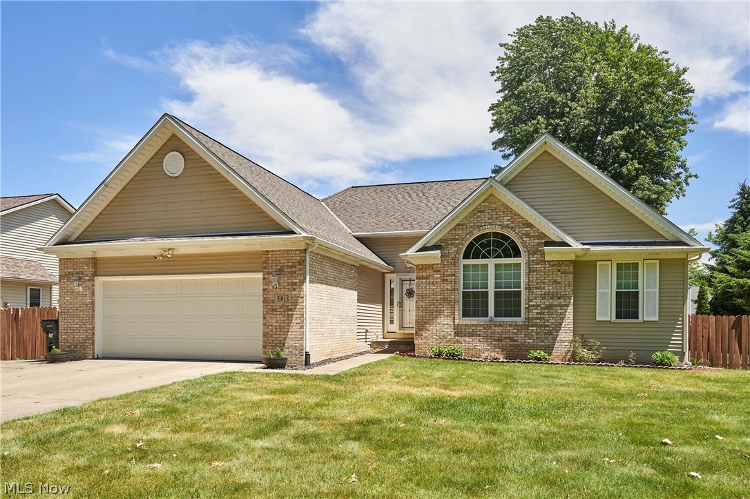 1963 Haines Road Madison, OH 44057 - Photo 2 of 34 Front exterior with brick and siding facade, an attached garage, arched window, and front lawn