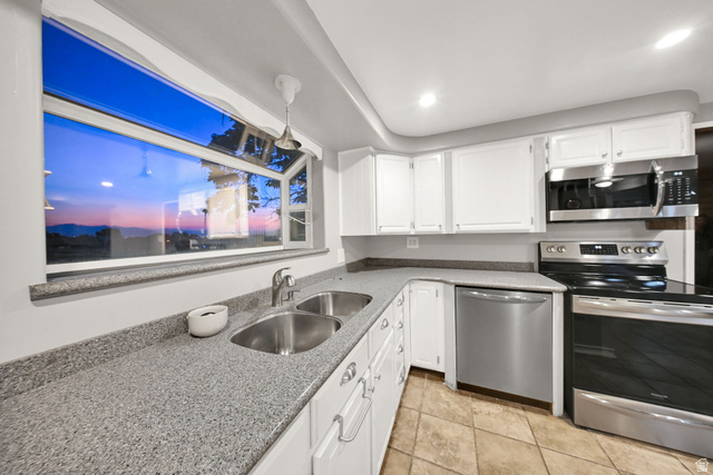 374 West Lakeview Road Lindon, UT 84042 - Photo 17 of 44 Kitchen featuring a corner window, granite-style countertops, white cabinetry, stainless steel appliances, and tiled flooring
