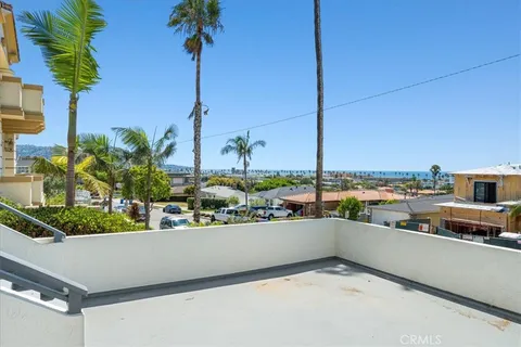 a kitchen with stainless steel appliances kitchen island granite countertop a stove a sink a refrigerator and white cabinets with wooden floor