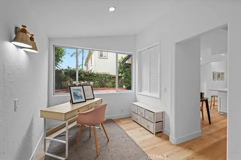 a big room with wooden floor a chandelier fan and windows