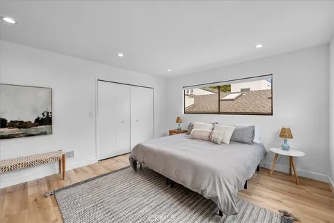 a view of a white house with large windows and a yard