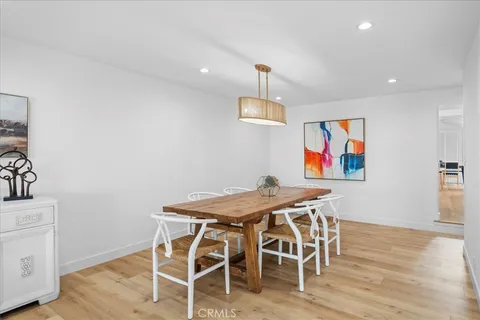 a kitchen with stainless steel appliances granite countertop a stove top oven a sink dishwasher and a refrigerator with wooden floor