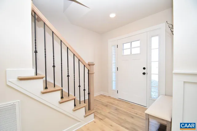 a view of a hallway with wooden floor and staircase