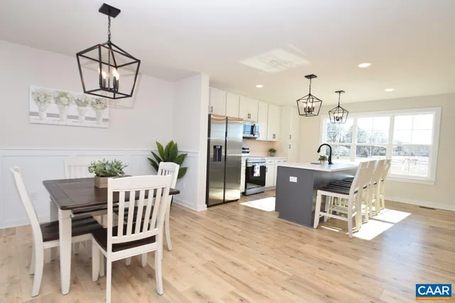 a dining room with wooden floor a chandelier a glass table and chairs