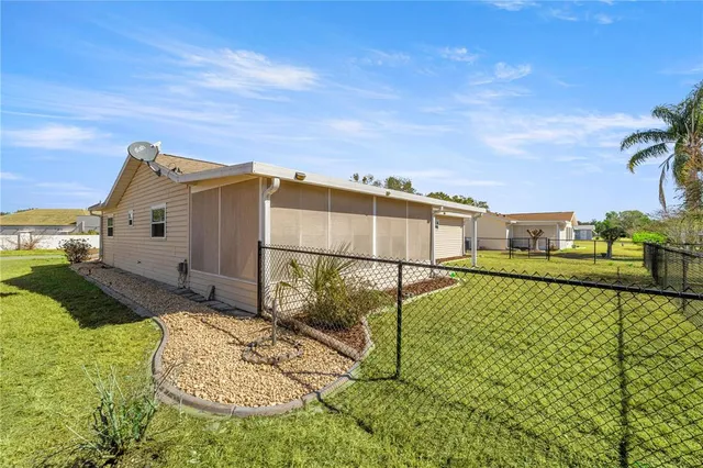 a backyard of a house with plants and large trees