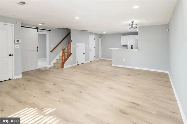 a view of empty room with wooden floor and window