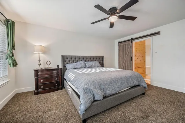 a bedroom with a bed and a ceiling fan