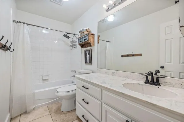 a bathroom with a granite countertop sink a toilet and shower