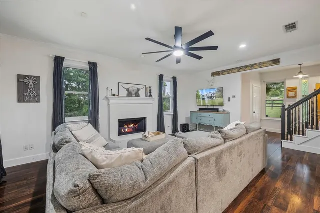 a living room with furniture a fireplace and a large window