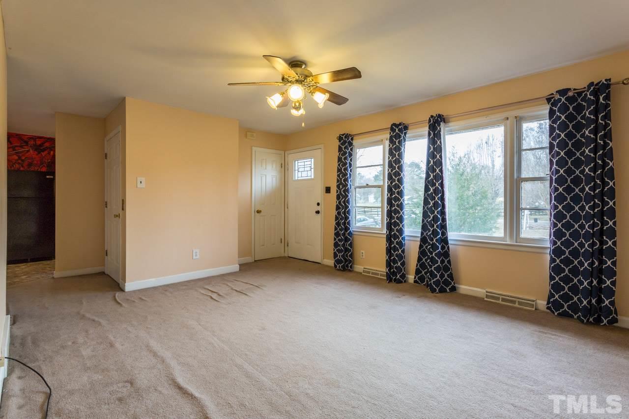 325 Hocutt Road Durham, NC 27703 - Photo 5 of 22 an empty room with windows and chandelier fan