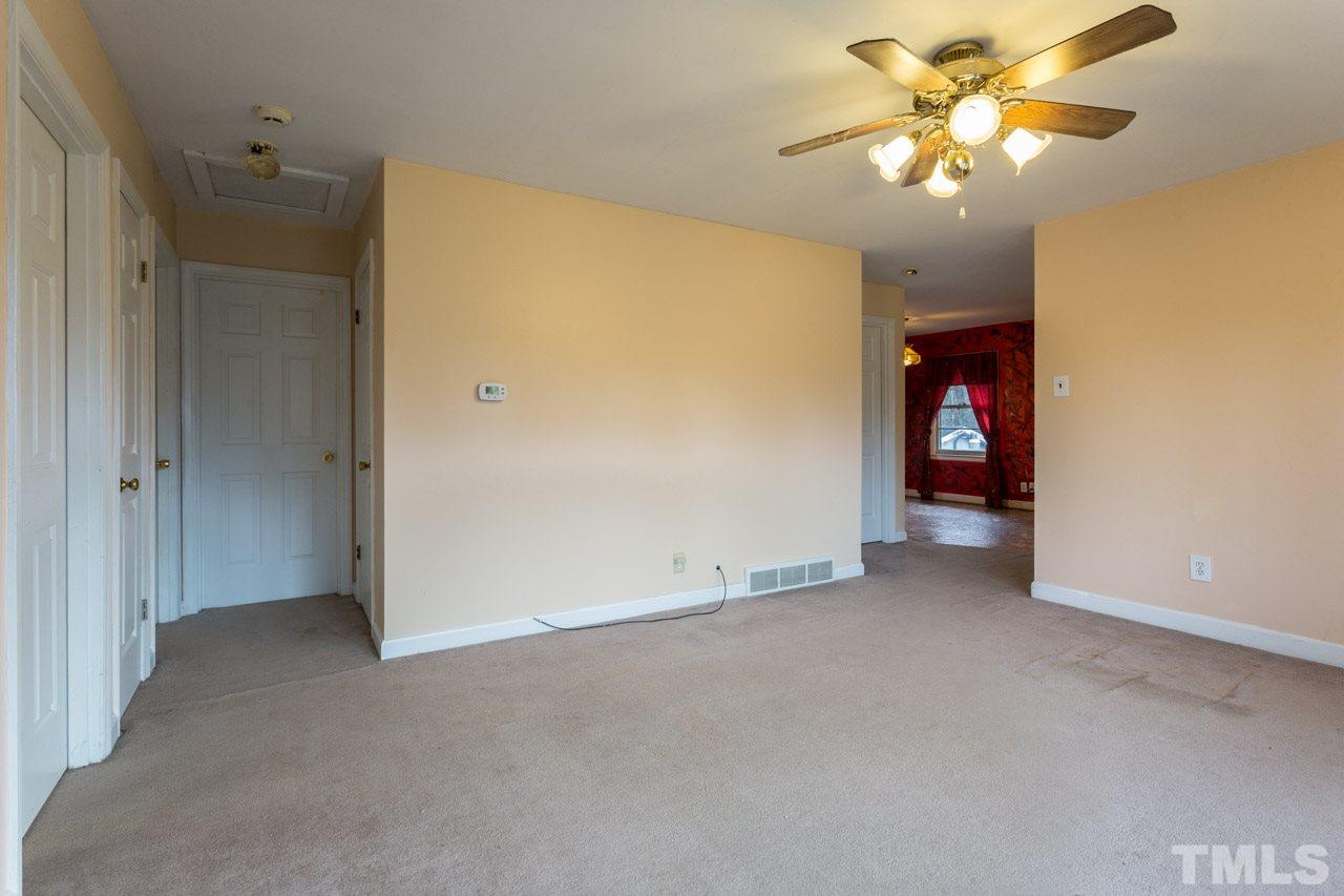 325 Hocutt Road Durham, NC 27703 - Photo 8 of 22 an empty room with a chandelier fan and closet