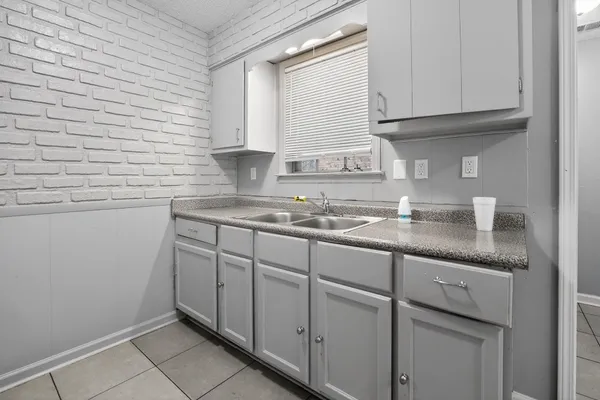 a kitchen with granite countertop white cabinets and a sink