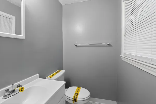 a bathroom with a sink a toilet and a window