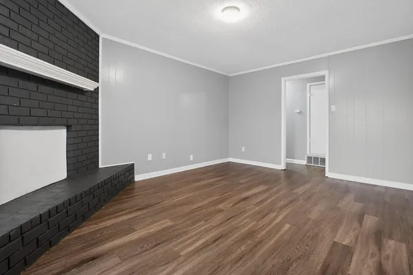 a view of a livingroom with wooden floor and staircase