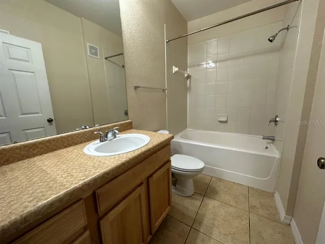 a bathroom with a granite countertop sink a toilet a mirror and shower