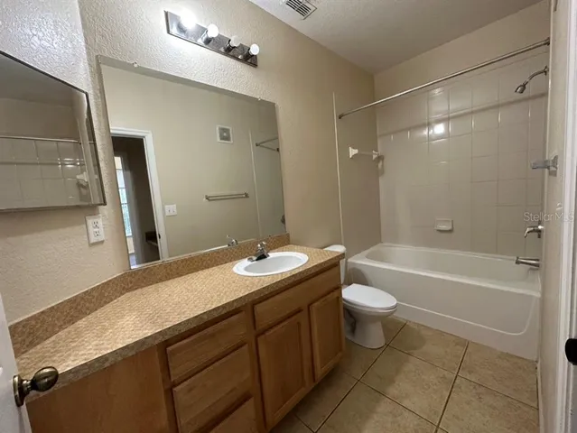 a bathroom with a double vanity sink toilet mirror and bathtub