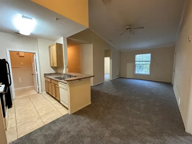a view of kitchen with cabinets and refrigerator