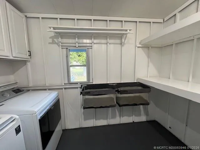 a utility room with cabinets washer and dryer