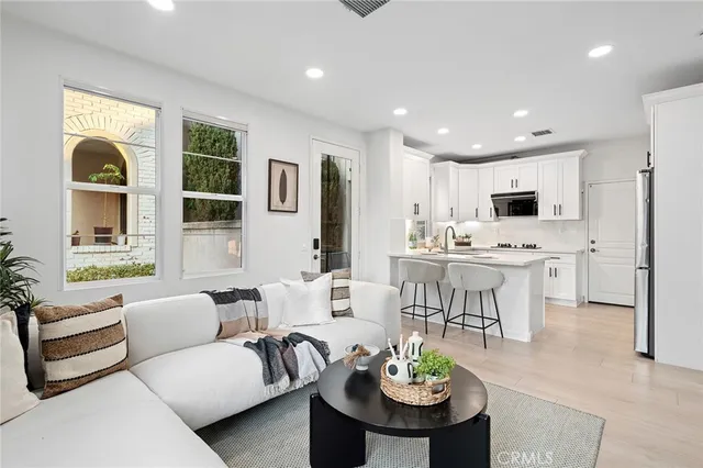 a living room with furniture kitchen and a table